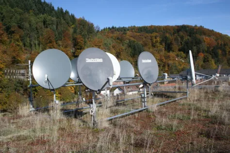 Gemeinschaftsanlage mit fünf Satellitenschüsseln auf einer Wiese